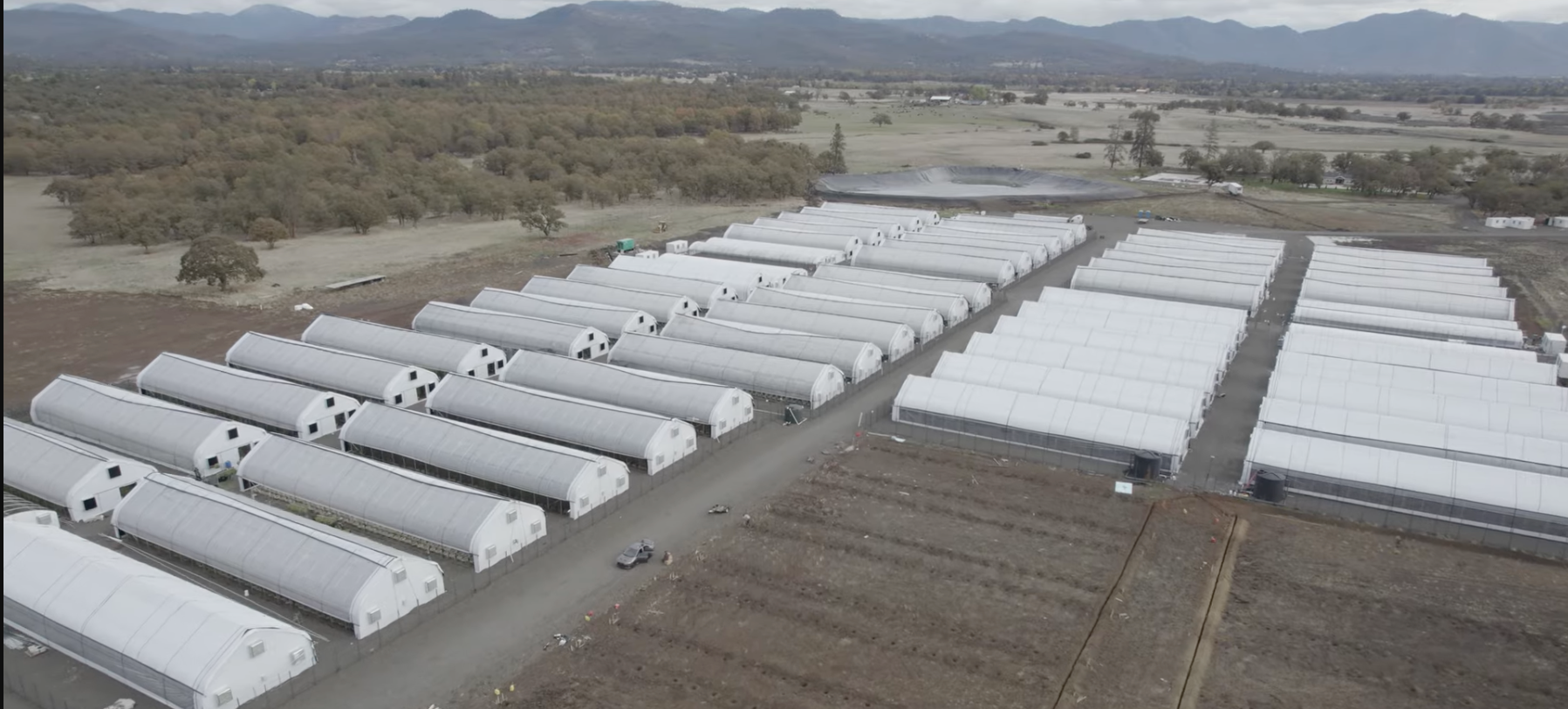Aerial view of a large agricultural facility with multiple white structures.